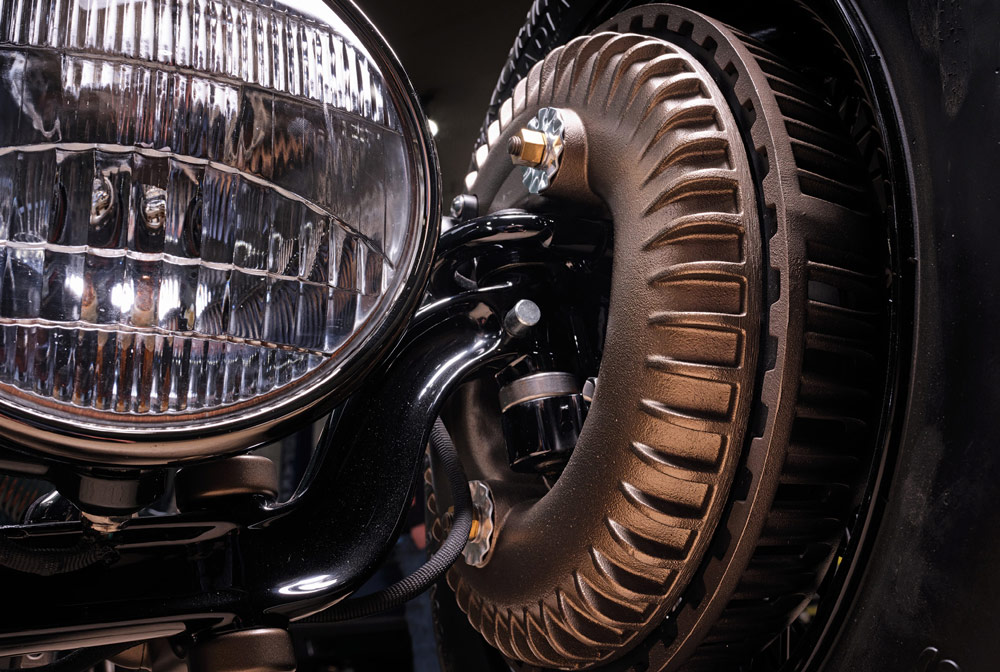 close up of a headlight and the inside of a rim on a green ’30 Ford