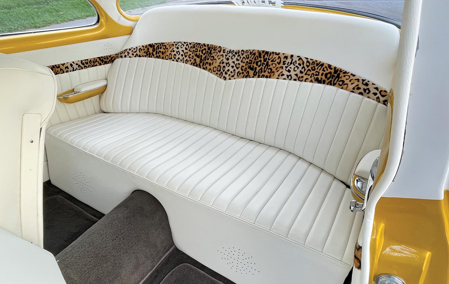 custom ’54 Chevy Bel Air's rear seating, furnished with white leather and a cheetah print accent