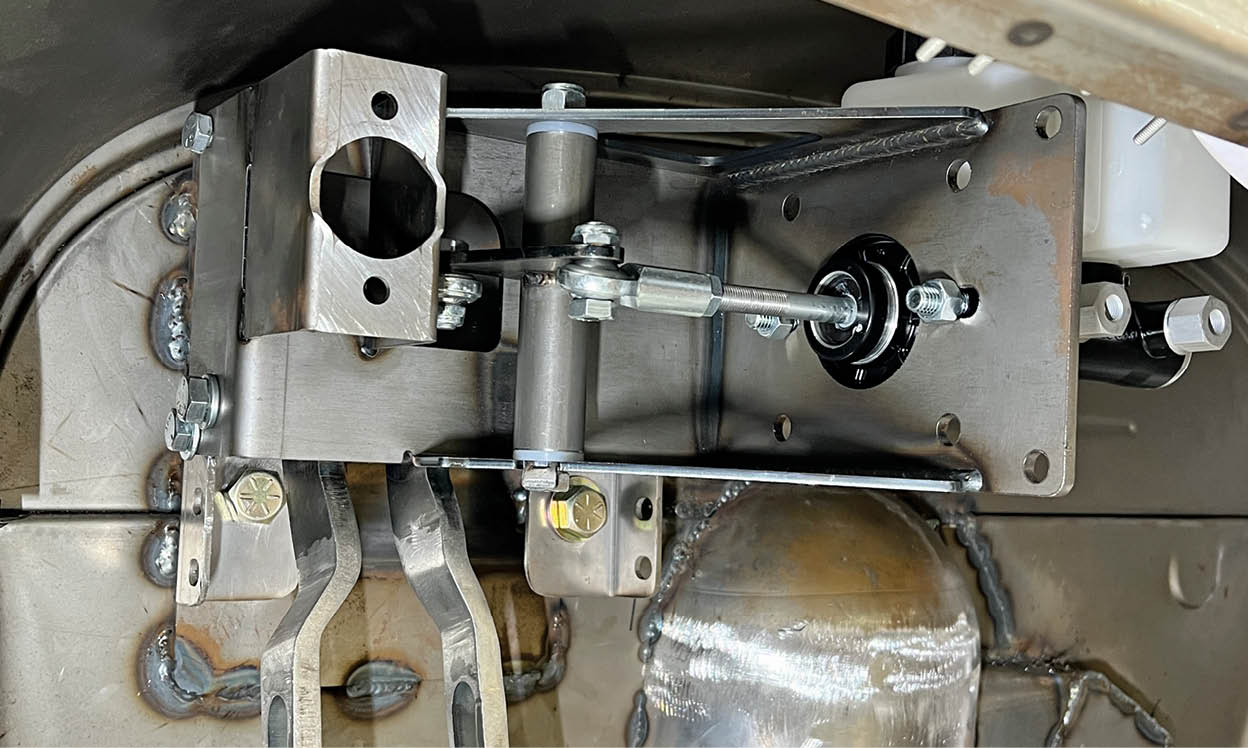 The pedal assembly mounts the clutch master cylinder 180 degrees or facing to the rear from the pedals. The linkage and 90-degree bellcrank for the brake master cylinder can be seen. 