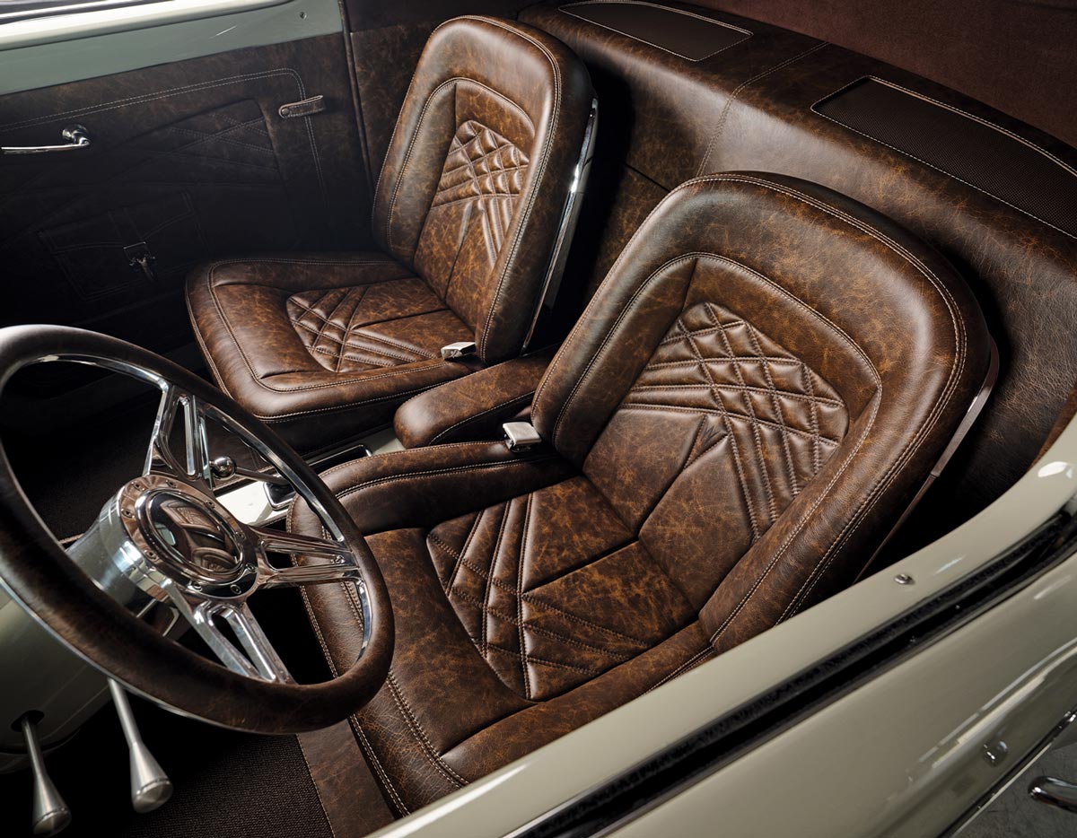 interior view of the desert beige ’41 Willys Coupe's cab, featuring ’64 Ford T-bird bucket frames covered in custom distressed brown leather