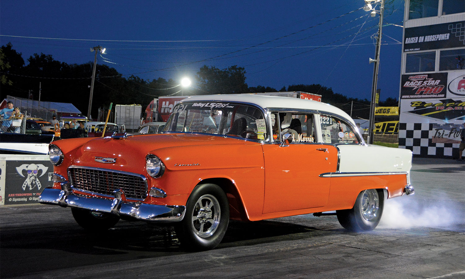 Orange and white chevy at a starting line at night