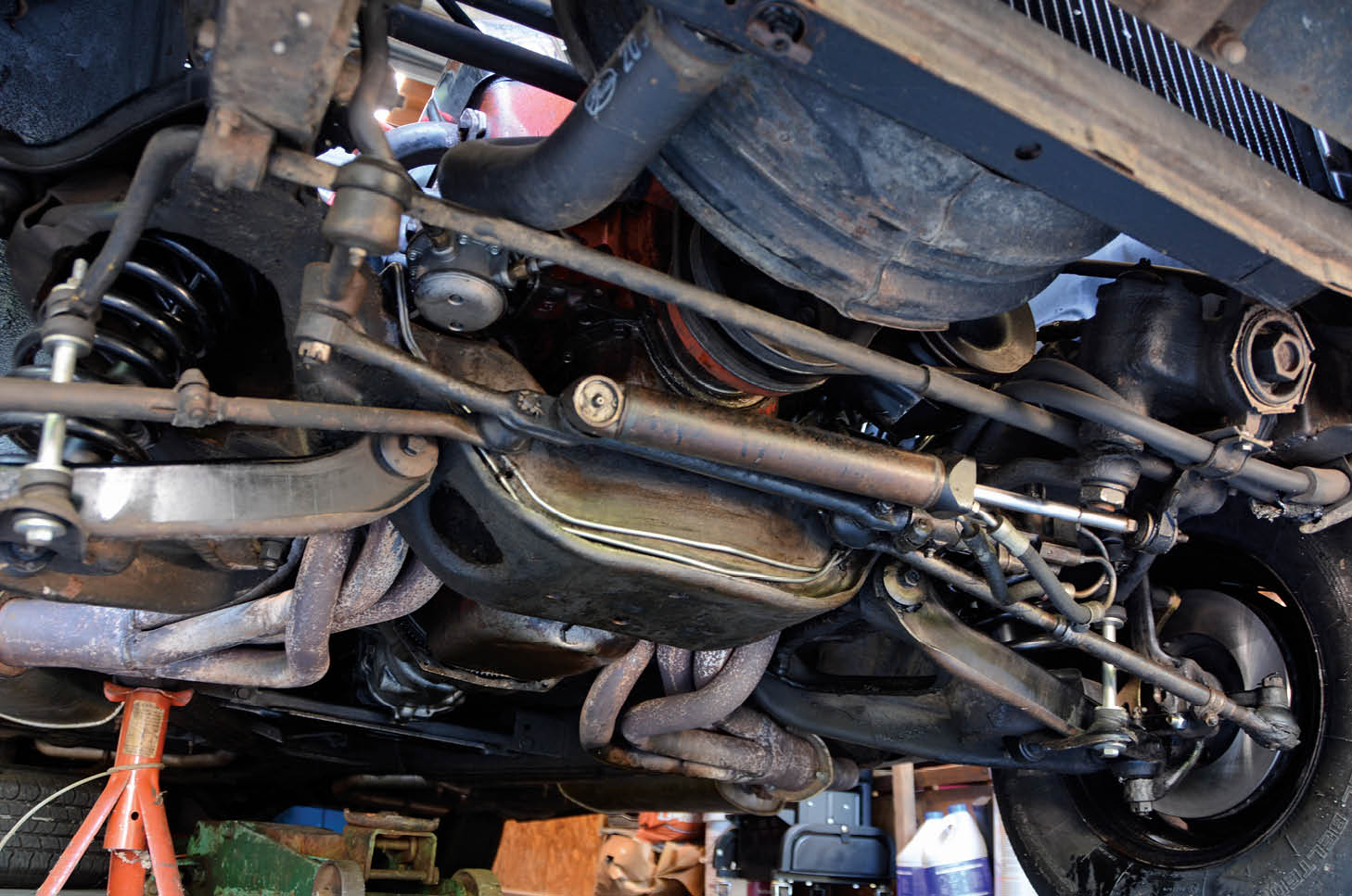 Underneath, we remove the old crossover brake line and replace it with the two new lines from the CPP kit.