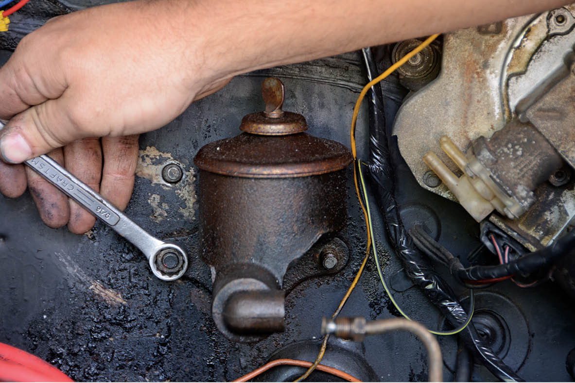 Next, the two 9/16-inch nuts are removed to free the master cylinder from the firewall.