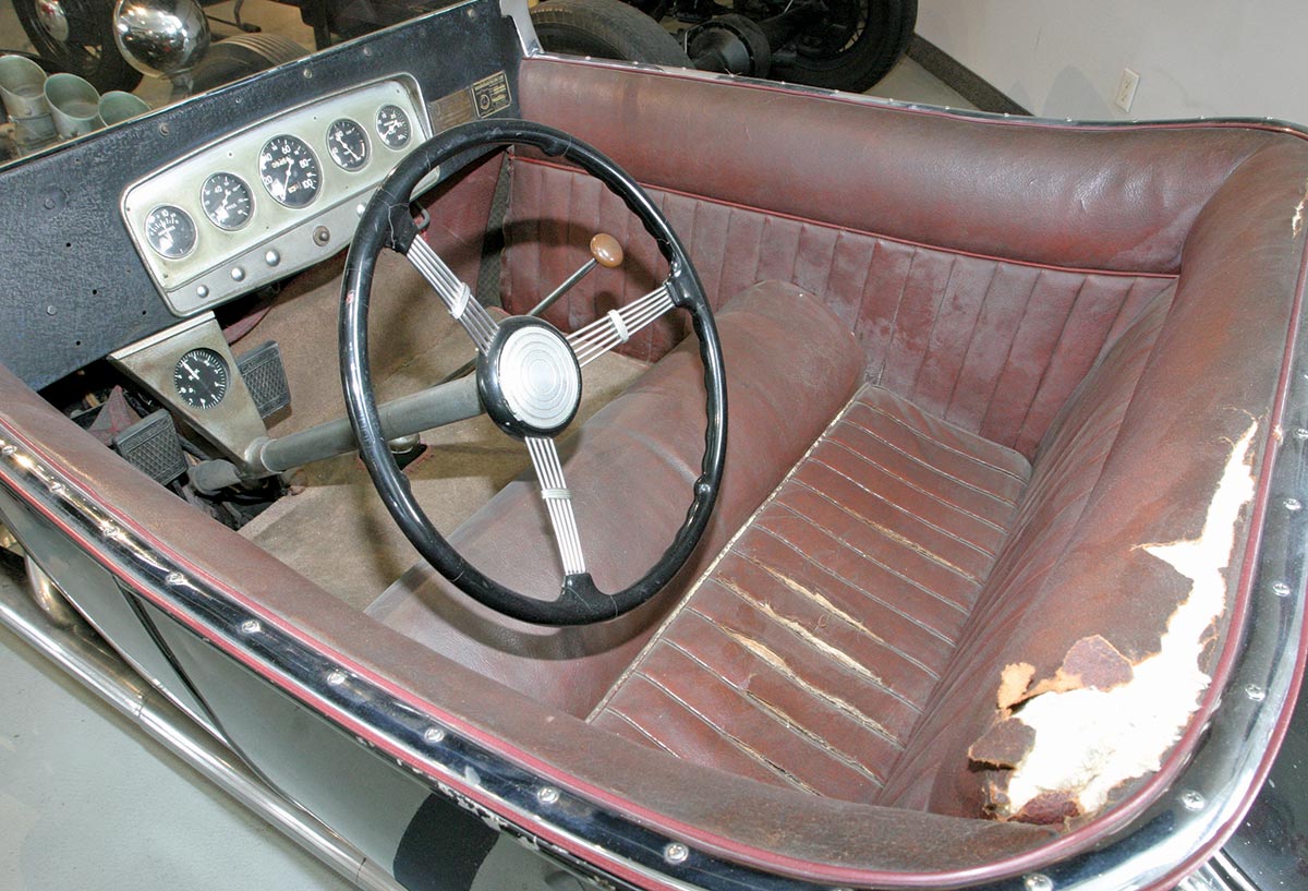 Landscape interior photograph perspective of the 1923 Isky tribute Ford roadster car seat; Inside is the the original Auburn gauge panel and gauges coupe with a banjo steering wheel.