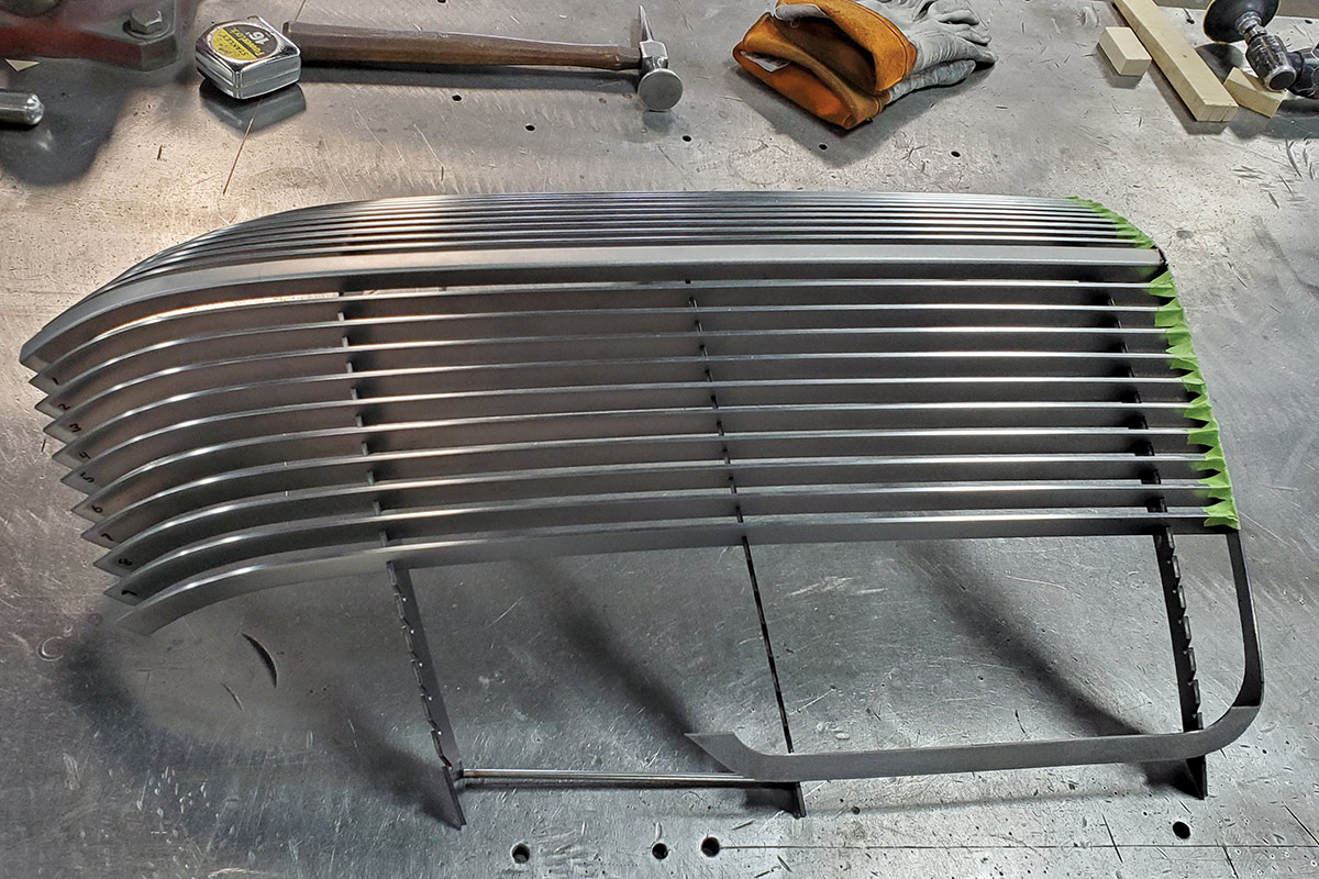 The grille bars being placed into the frame while its laying on a metal table