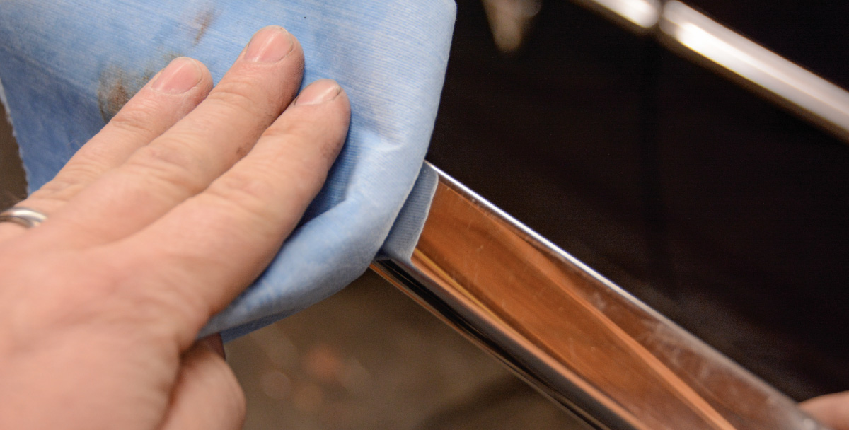 close view of a hand using a cloth to wipe the trim down