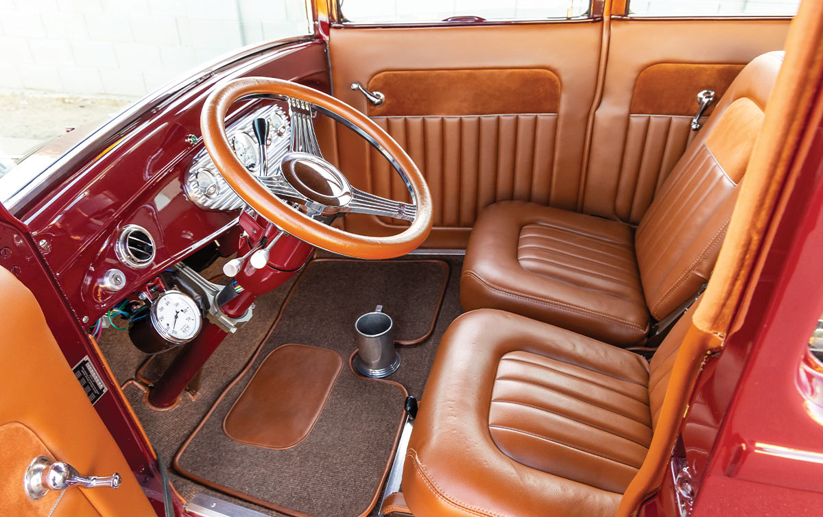 view from the open driver side door of the Ford Model T Sedan interior with a focus on the dashboard, steering and front bucket seating