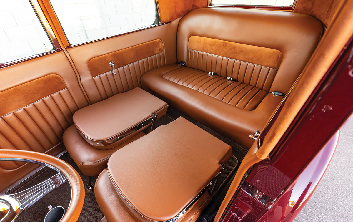 view from the open driver side door of the Ford Model T Sedan interior with the front bucket seats folded to show the rear passenger bench seating
