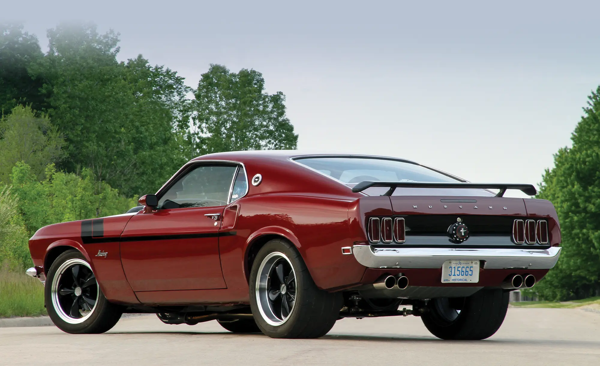 red and black '69 Ford Mustang 3/4 view from rear