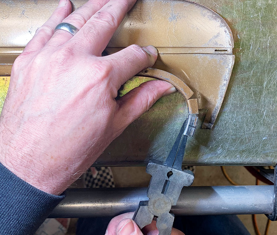 piece of trim being reshaped using hand tools