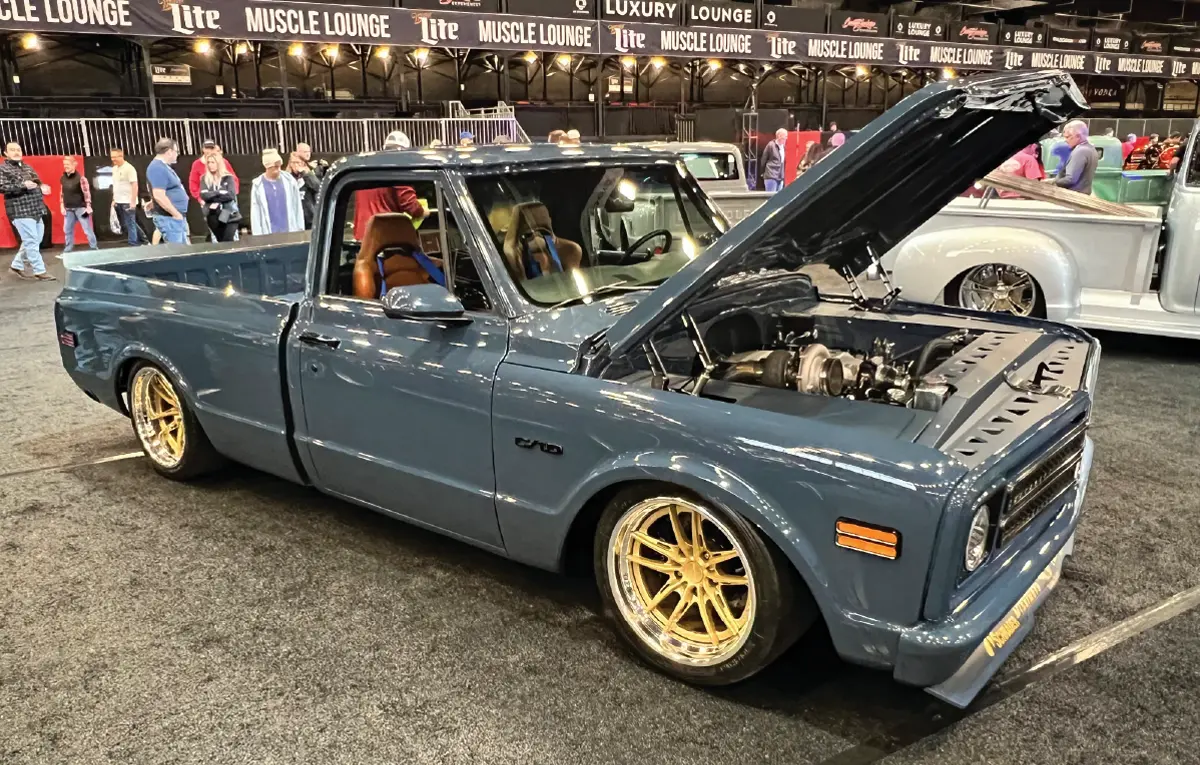 passenger side of a slate blue pickup truck with its hood open