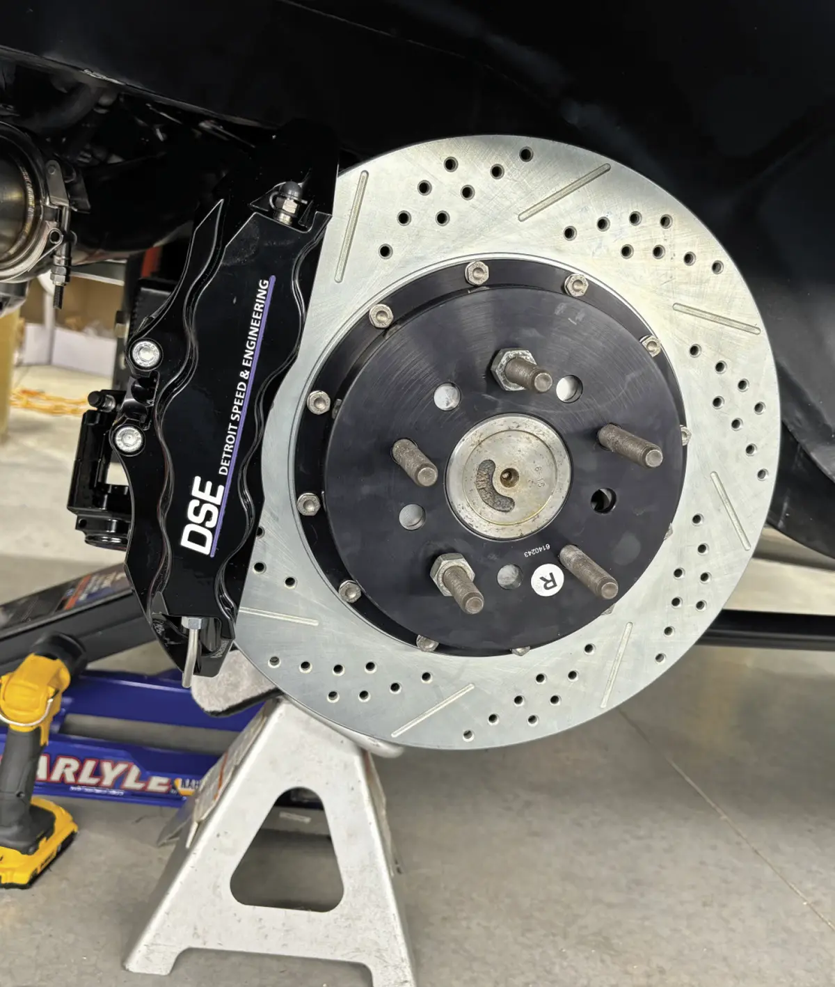 close up of the rear six-piston calipers and rotor in place labeled with an "R" sticker