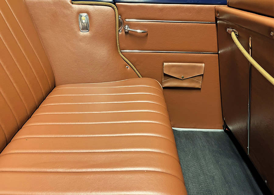 finished back seat area with vintage ash trays, map pockets, rubber floormats, and leather seats