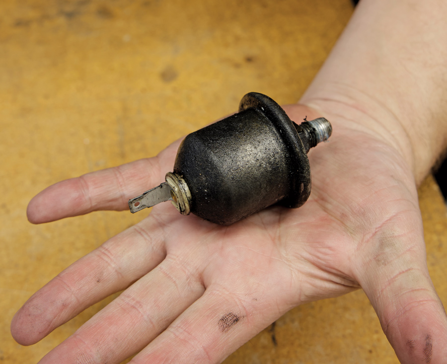 hand holding original gm oil pressure sender 