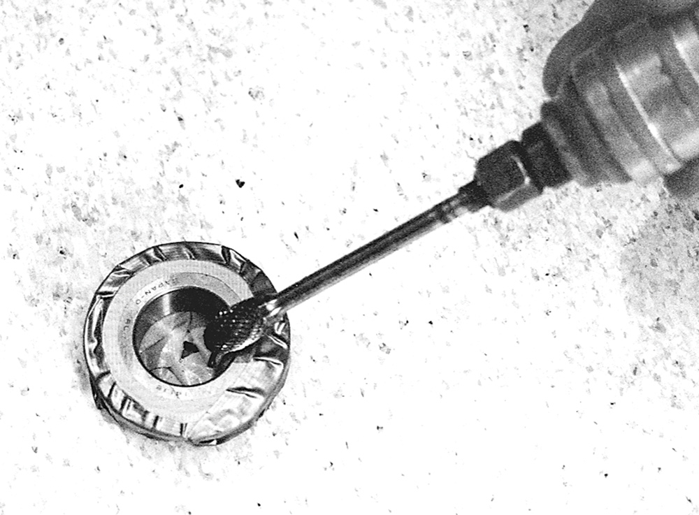 black and white photo of die grinder sharpening edge of new bearing 