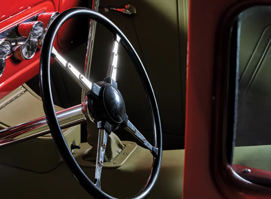 Vintage steering wheel in a meticulously restored 1930 Ford Sedan hot rod