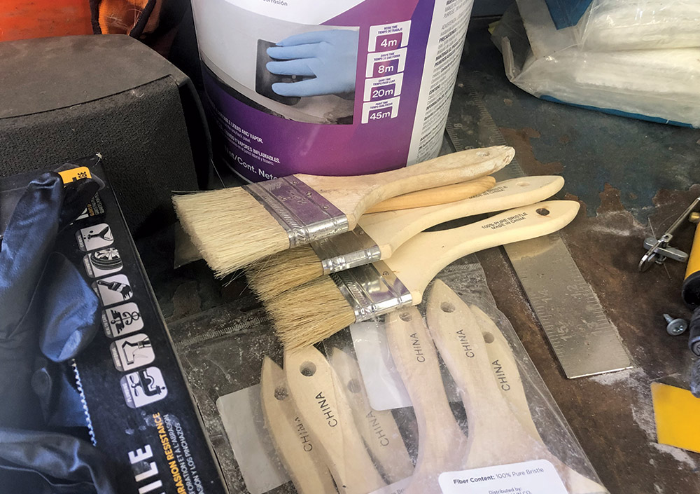 multiple paint brushes sitting on workbench 