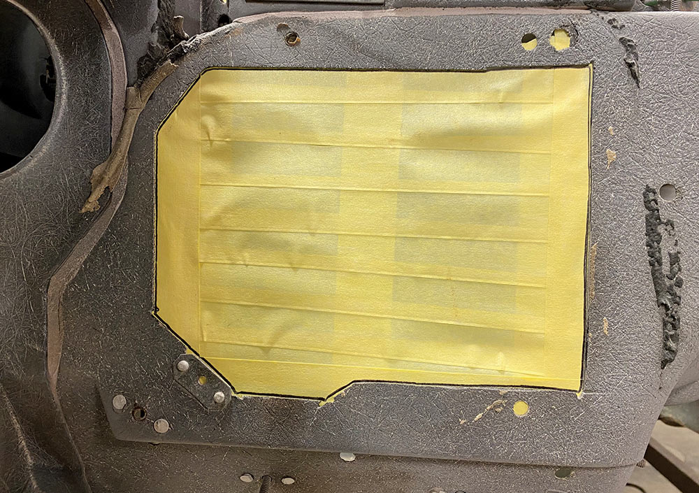 firewall hole traced with black marker on yellow masking tape