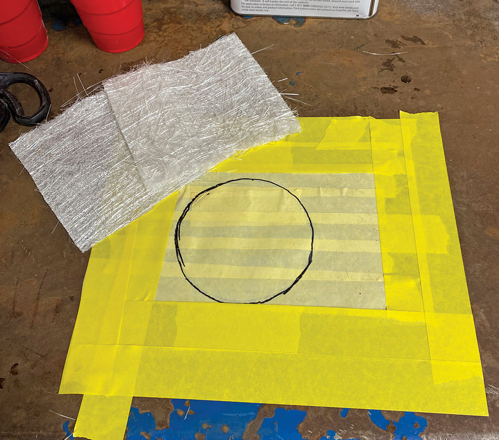 circle the size of the circle holes in engine compartment traced onto yellow masking tape and placed on workbench next to fiberglass mats