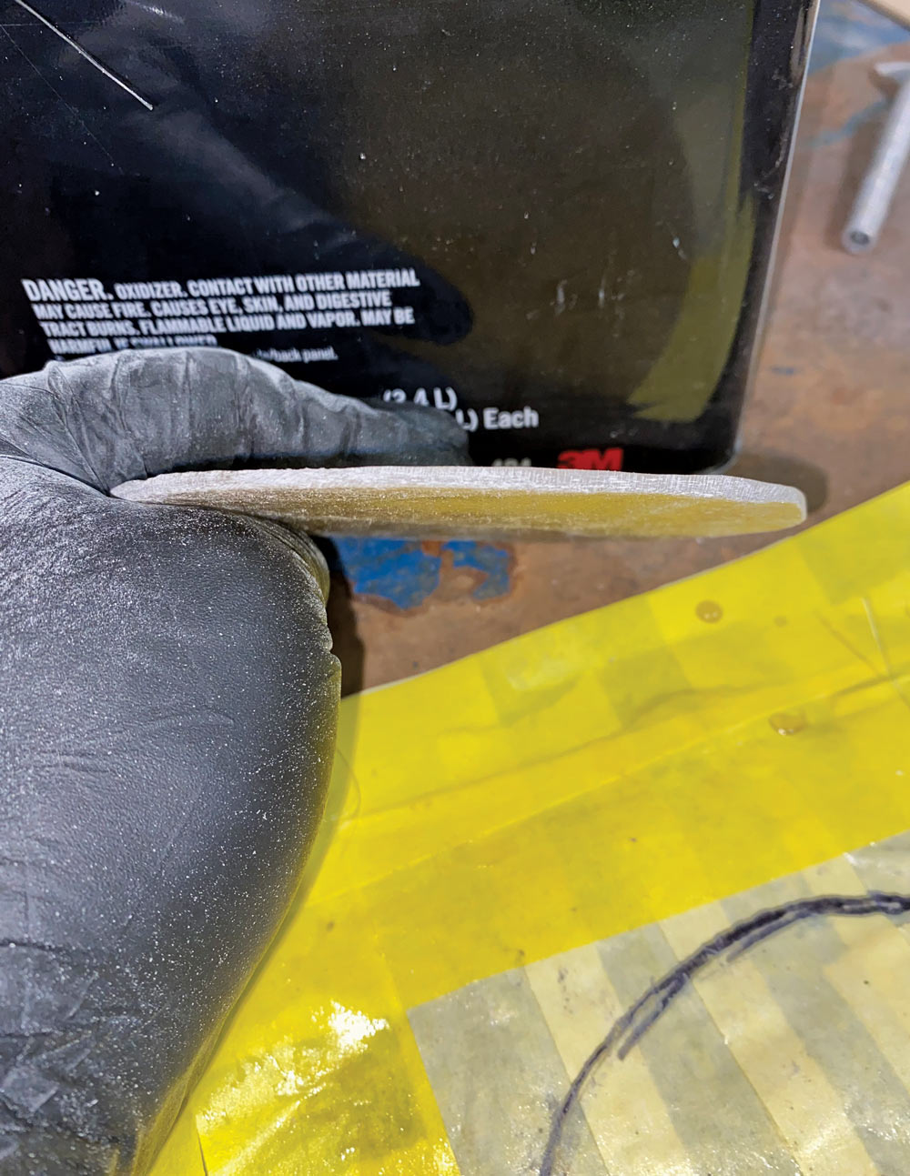 hand holding circle shaped fiberglass up to show thickness 