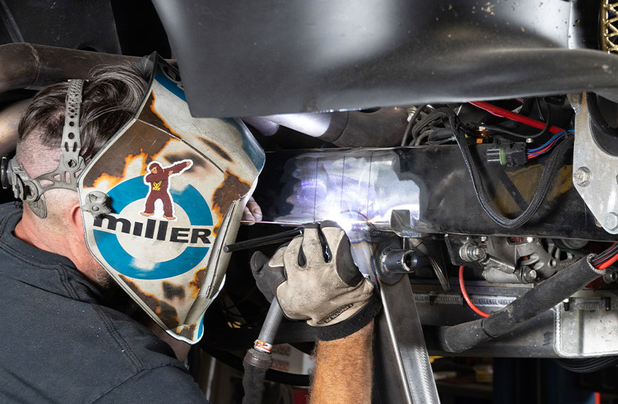 Welding in progress on the custom front suspension of the 1955 Chevrolet Bel Air gasser for added reinforcement