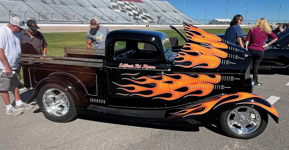 black truck with flames at a car show