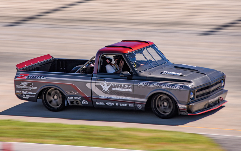 gray truck with red roof top driving on a track