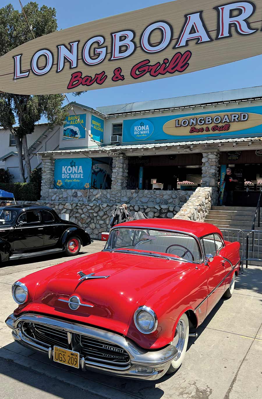 A vibrant red 1956 Oldsmobile 88 displayed outside a restaurant