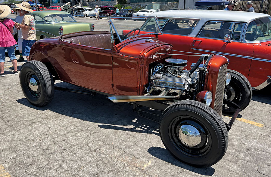 A copper 1932 Ford roadster with a polished engine on display