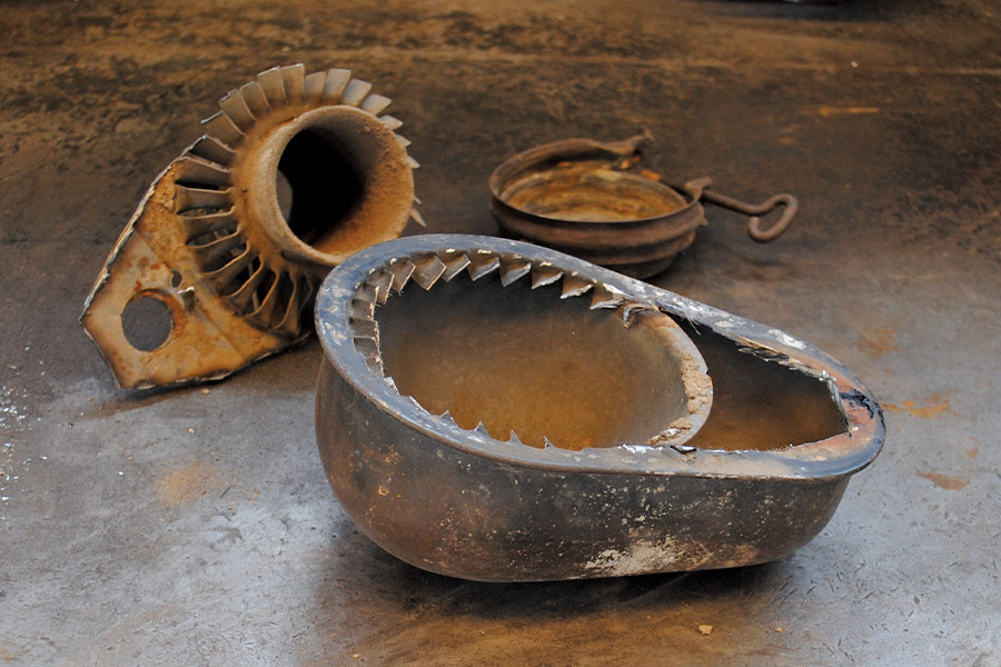 The disassembled parts of an aged air filter housing placed on a workshop table