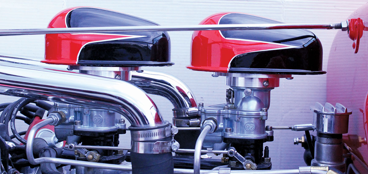 Close-up of dual carburetors with custom red and black air cleaners on a 1926 Ford Roadster