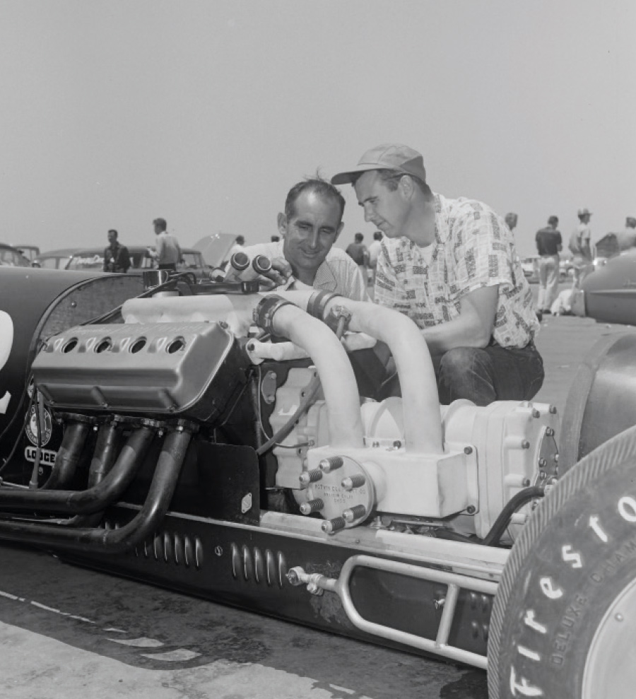 two men looking at Kenny Lindley’s “Miss Fire” dragster