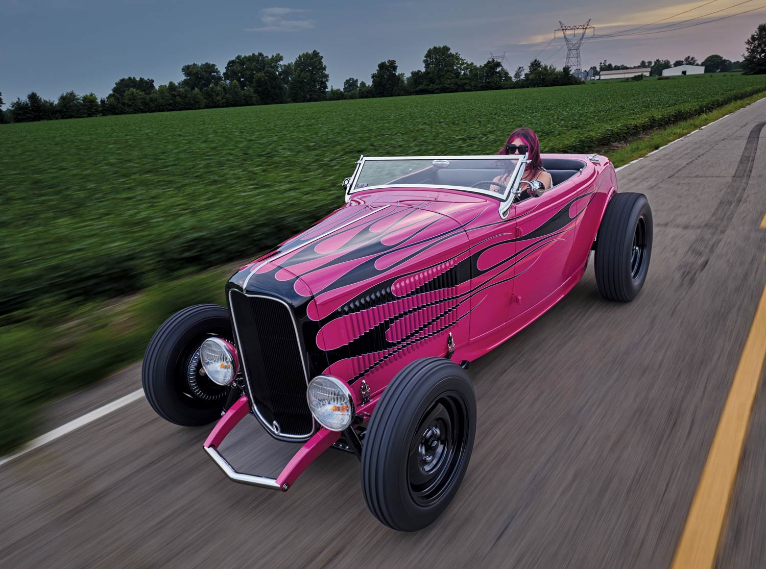 High-angle front view of a pink 1932 Ford Roadster, featuring a black grille and flames