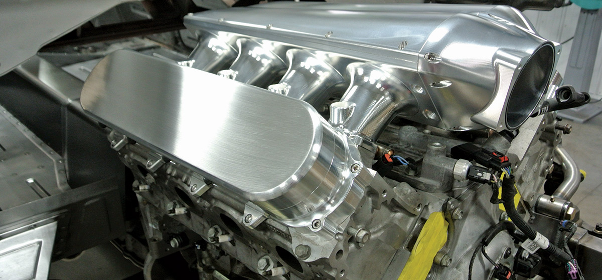 Closeup of engine fitted with an intake plenum and valve covers by BBT Fab