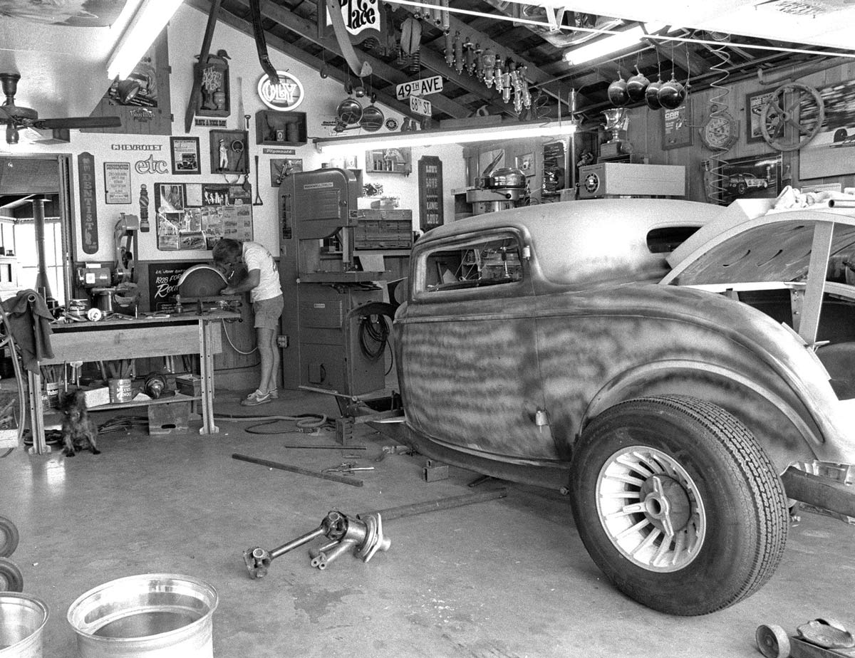 black and white photo of a person working in a garage