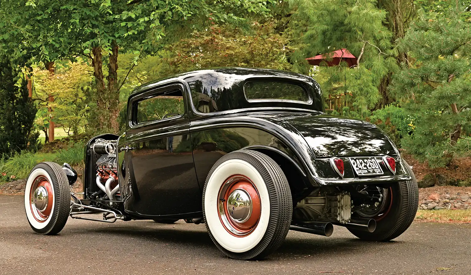 1932 Ford Coupe rear three-quarter view chopped roof whitewall tires and polished hubcaps aggressive stance