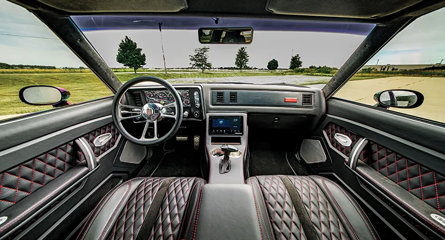 Engine bay 1985 Chevy Monte Carlo red accents chrome pipes performance build modernized classic