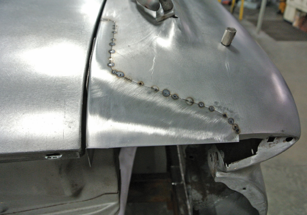 1959 Impala fender repair with weld points aligning a newly fabricated patch panel