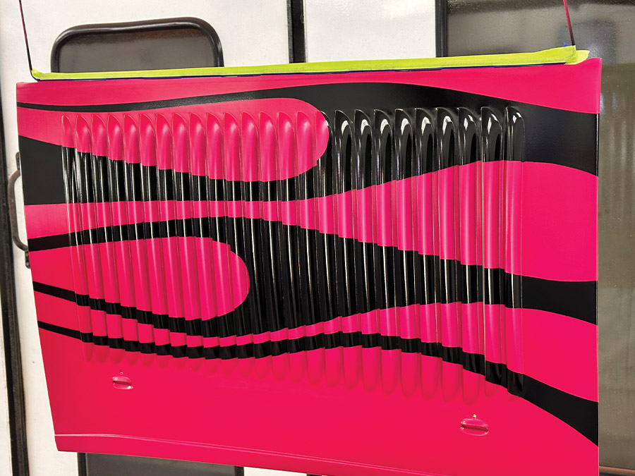Completed hood panel featuring bold black flames over a hot pink base, showcasing precise custom work