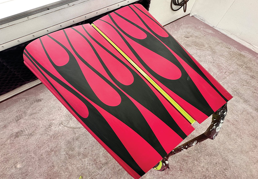 Hood panel painted with bold black and pink flames, featuring sharp contrast and precision