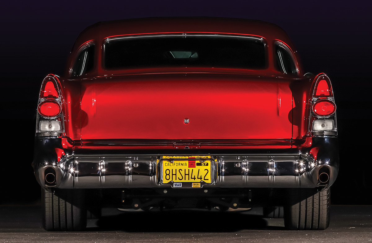 1957 Buick rear view red paint chrome tail fins night lighting