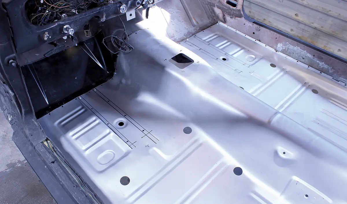 Floor pan fitted in 1965 Ford Mustang interior, aligned for welding and securing