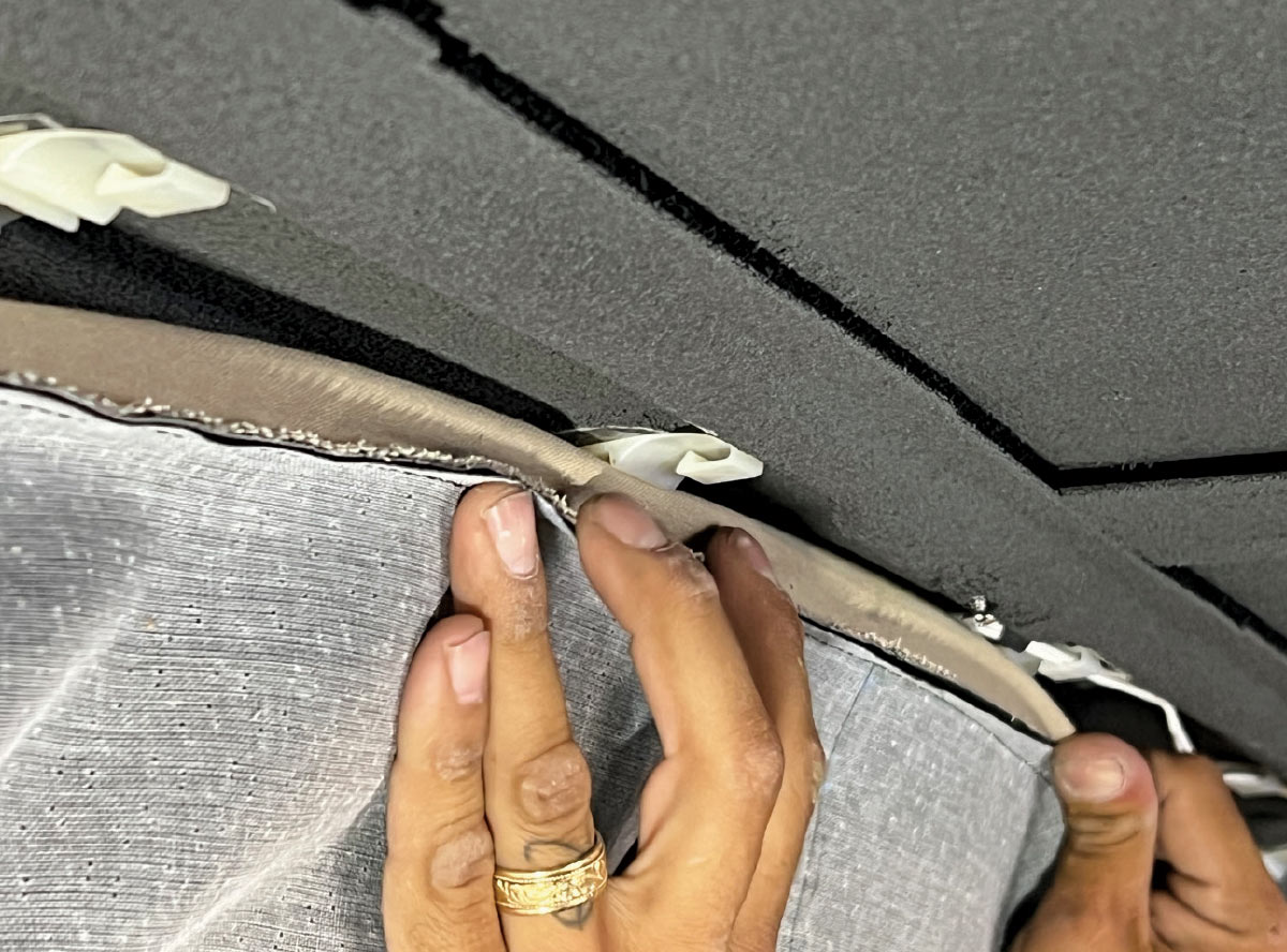 Clipping and securing the headliner edges for a proper fit in a 1970 Chevy Nova