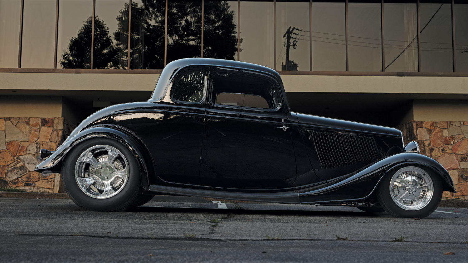 1933 Ford Five-Window Coupe in deep black with a sleek, chopped stance and polished wheels