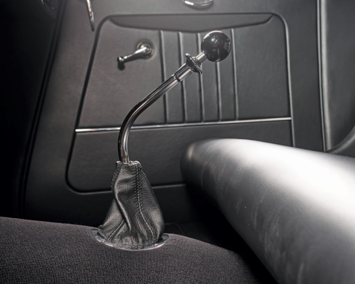 1933 Ford Five-Window Coupe shifter with a black knob and leather boot on a clean black carpeted floor