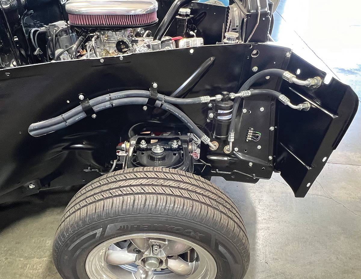 Side view of a classic car's engine bay with AC hoses and a receiverdrier installed