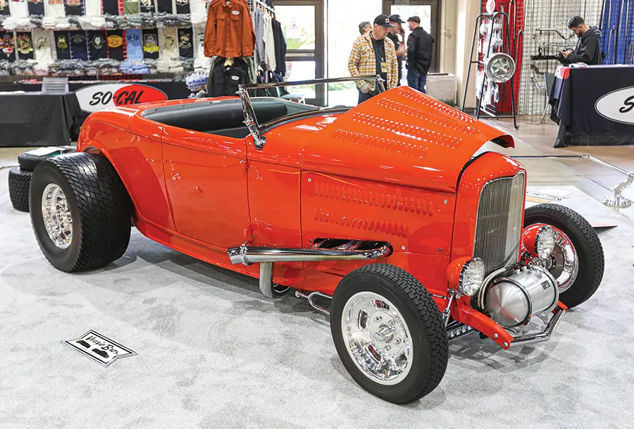 Classic red 1932 Ford roadster with polished Halibrand wheels, displayed at the So-Cal Speed Shop booth