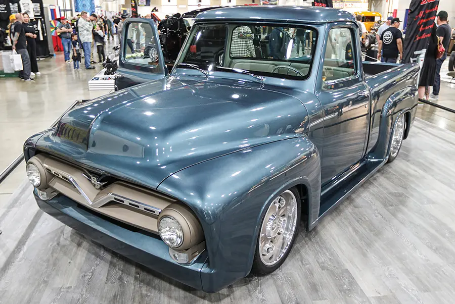 Smooth blue 1956 Ford F-100 with a lowered stance, billet wheels, and a fully custom interior