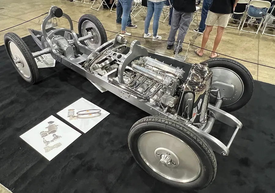 Fully exposed custom chassis with a polished V8 engine, intricate suspension, and vintage race styling