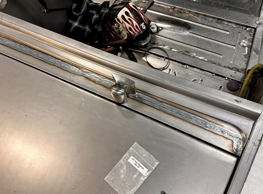 A freshly welded trunk panel seam on a 1932 Ford Roadster, prepped for further metal finishing